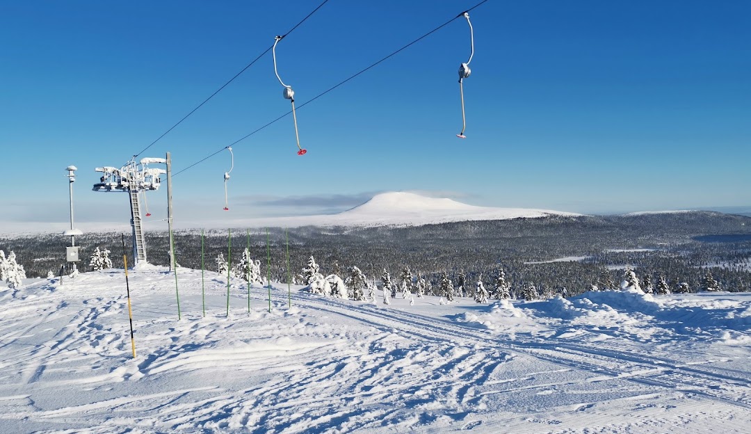 Ski lift operating at Idre Himmelfjäll ski resort in Central Sweden. A skier glides down the snow-covered slopes, showcasing a vibrant winter sports scene.