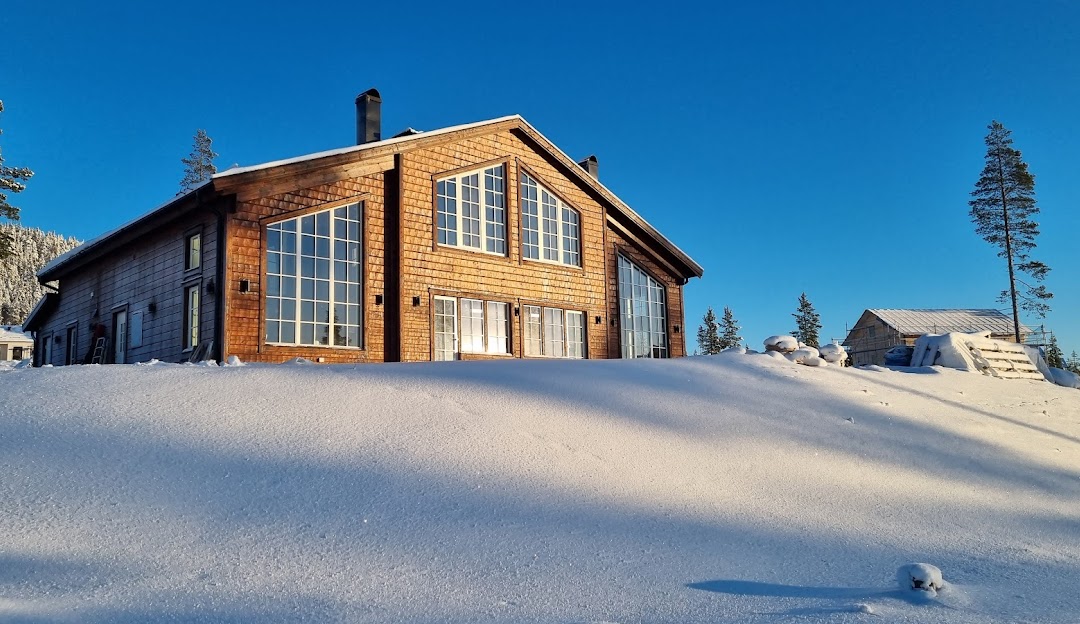 Stunning winter scenery at Idre Himmelfjäll sports centre in Central Sweden, showcasing a picturesque lodge against a backdrop of snow-covered mountainsides.