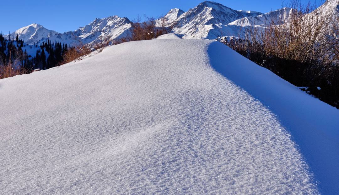 A skier gliding down the slopes of Snow Ridge in The Adirondacks, Turin, New York, experiencing the stunning winter scenery of the mountainous ski resort.