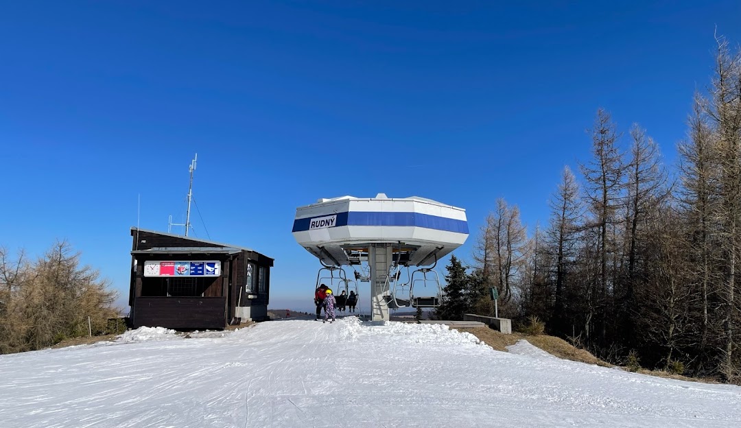 A picturesque view of the Telnice Ski Resort in the Ústí nad Labem Region of Czech Republic featuring a ski lift and a bustling winter sports scene amid snowy mountains.