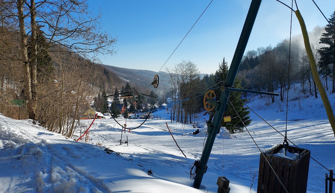 A winter sports setting in Telnice Czech Republic showcases a ski lift amidst a ski resort with a quaint chalet nearby representing an inviting scene of winter sports activities.