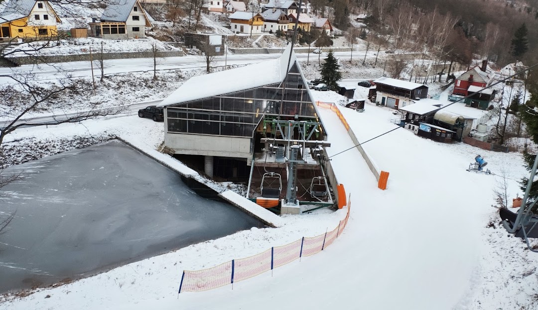 Winter sports resort in Telnice in Ústí nad Labem Region, Czech Republic, featuring a bustling scene of skiers, a challet and a ski lift.