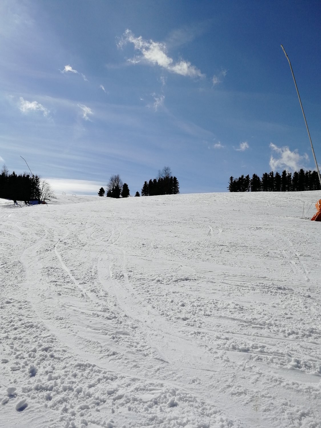 Ski Chalet in Telnice, Czech Republic during winter, featuring a bustling ski resort with people engaged in winter sports, accompanied by a prominent ski lift in the background.