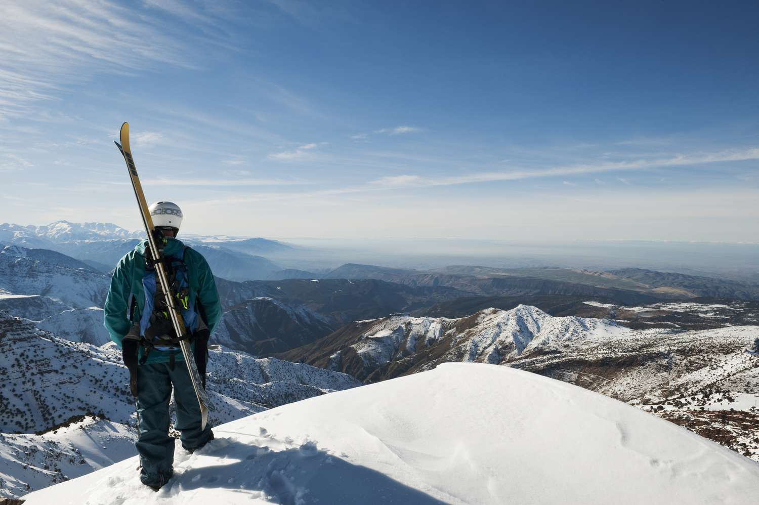 Oukaïmeden in Morocco - a man standing on top of a snow covered mountain.