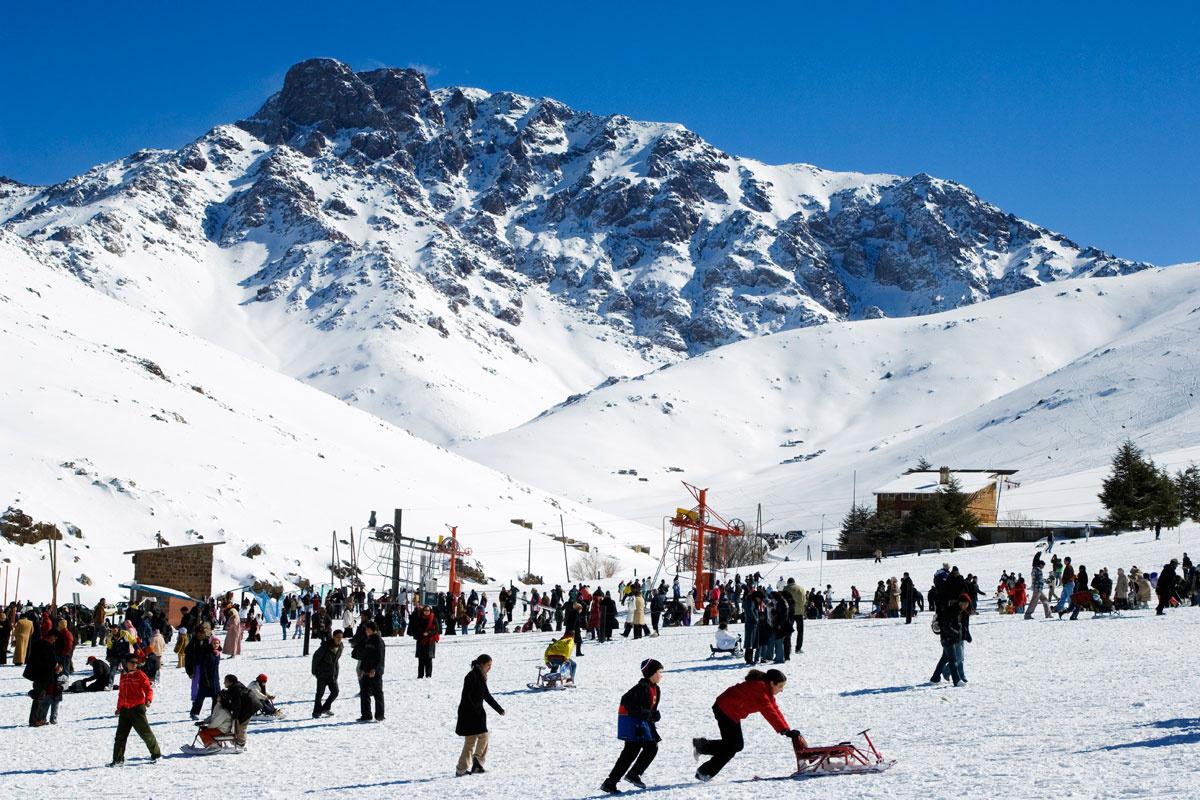 Oukaïmeden in Morocco - a group of people playing in the snow.