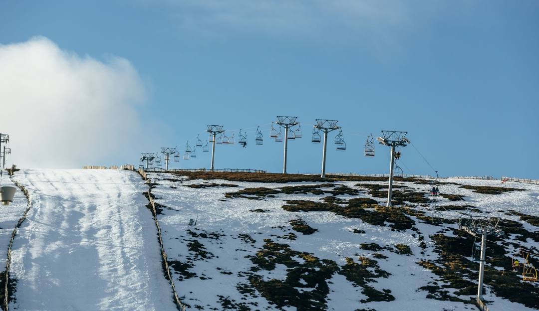 View of Lecht Ski Centre in Scotland featuring a ski lift chalet and winter sports scene indicative of a bustling ski resort.