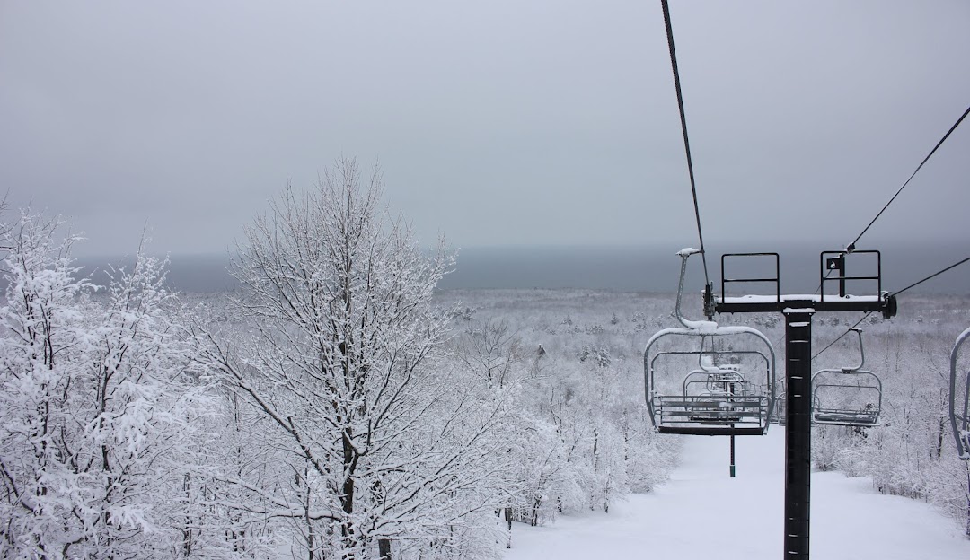 Ski lift going up the snow-covered Porcupine Mountain in Ontonagon, Michigan. A picturesque winter sports scene at a ski resort, surrounded by stunning winter scenery.
