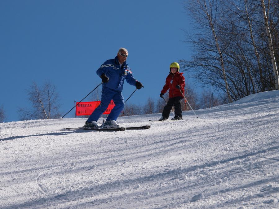 St.Gréé in Italy - two people skiing down a hill on a sunny day.