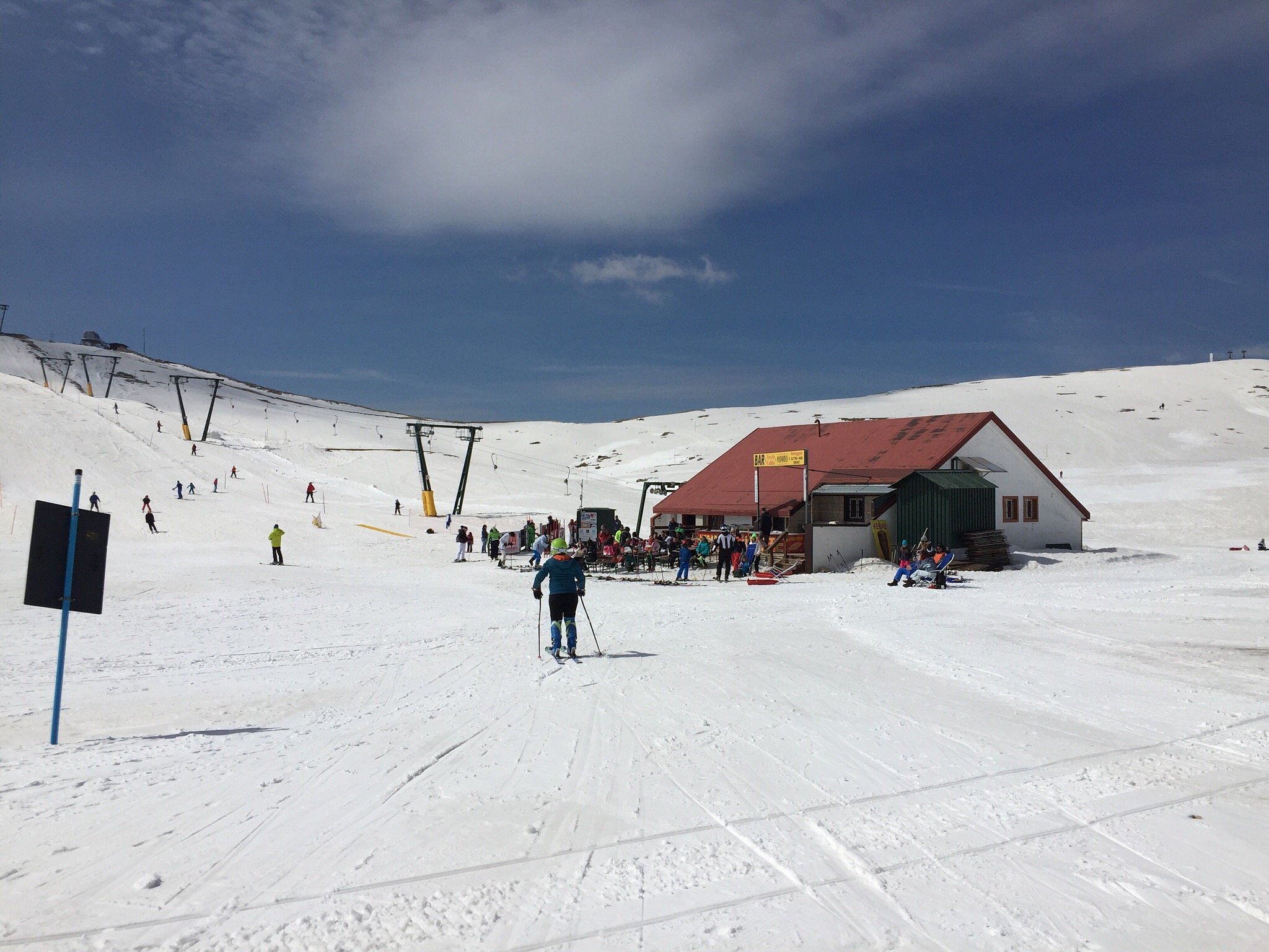 Ski resort in Campocatino, Italy showing a winter sports scene. Visible elements include a chalet, snow-covered slopes and a skier enjoying the run.