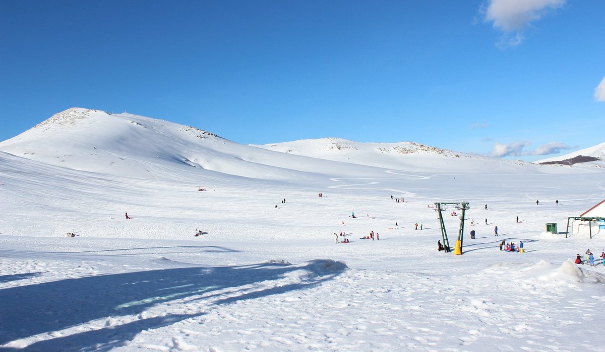 Campocatino in Italy - a group of people skiing down a snowy mountain.