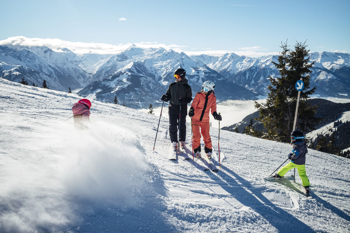 Schmittenhöhe in Austria - a group of people skiing down a mountain.