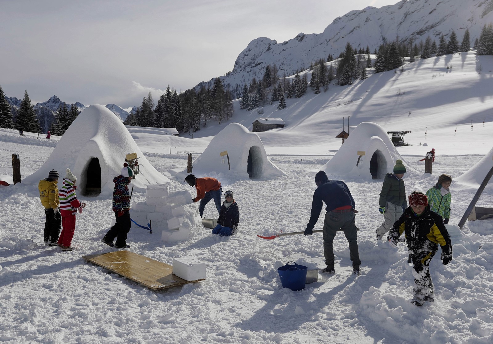 San Simone in Italy: a group of people building snow forts in the snow.