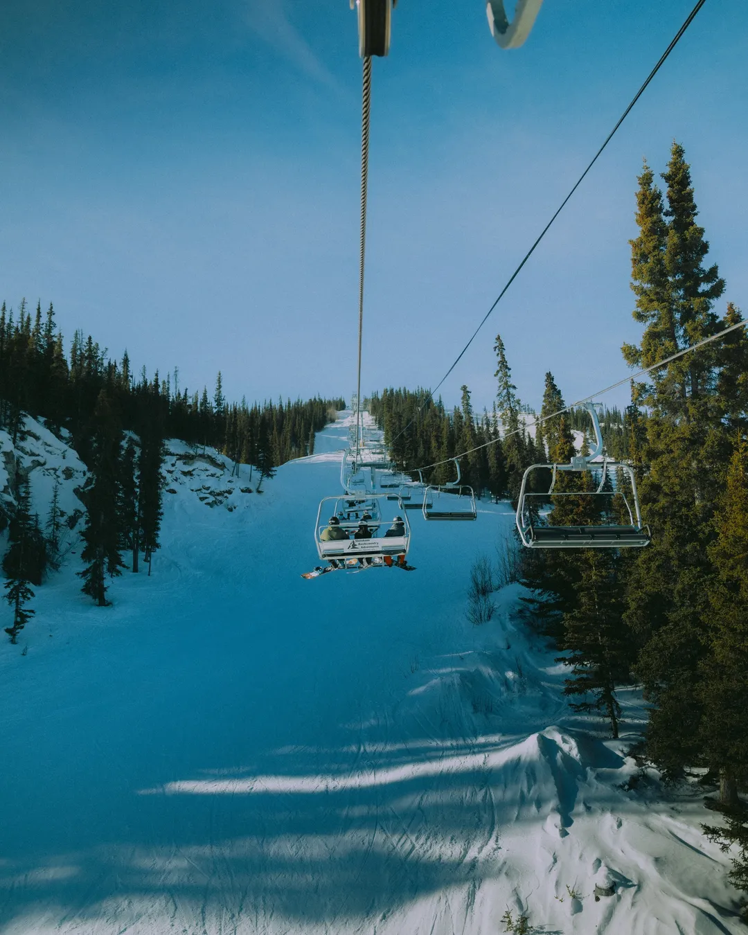 Mount Sima in Canada - a ski lift going down a snowy slope.