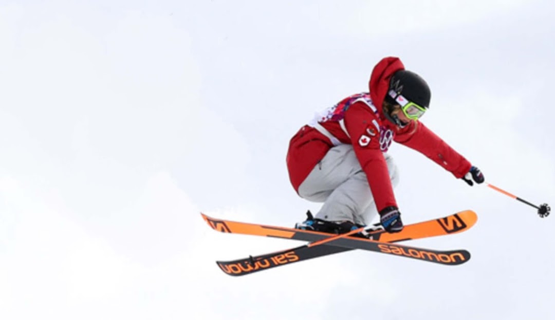 A skier enjoying a day on the slopes at Mount Sima in Whitehorse, Yukon, Canada with a charming chalet in the background amidst a picturesque winter sports scene.