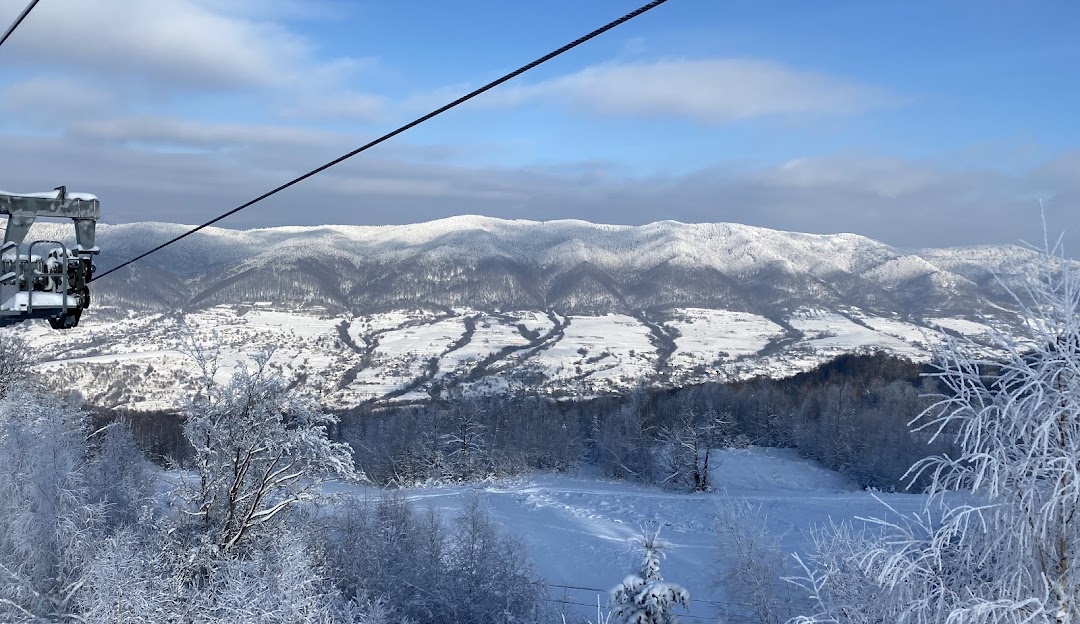 Stunning winter scenery at Zakarpattia, Ukraine, featuring a ski resort with a charming chalet, amidst a captivating snow-covered landscape, embodying the essence of winter sports.