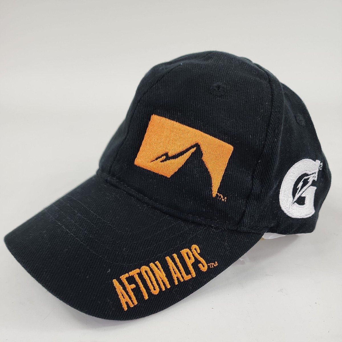 Afton Alps in USA - a black hat with an orange arrow on it.
