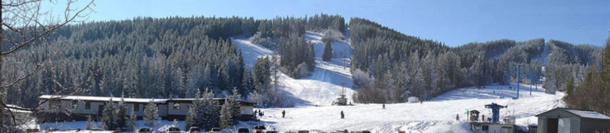 View of Silver Summit a ski resort in Alberta Canada. Image captures a winter sports scene with a ski lift leading up to snow-covered slopes.