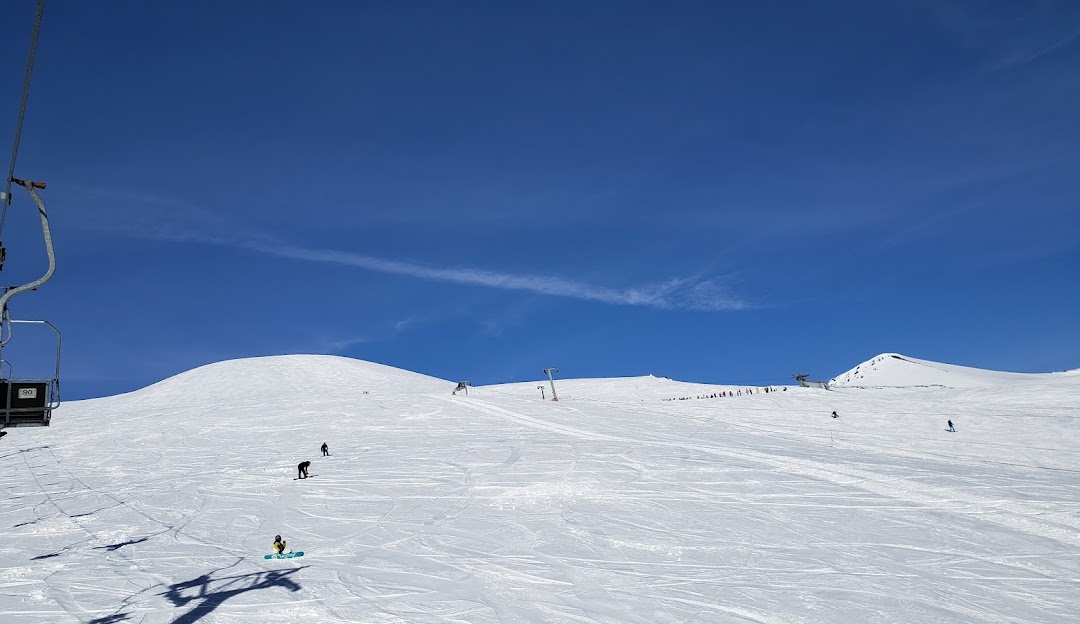 Skiers enjoy a winter day at Centro de Ski Araucarias - Volcán Llaima in Vilcún, Araucanía, Chile. A chalet overlooks the vibrant ski resort scene.