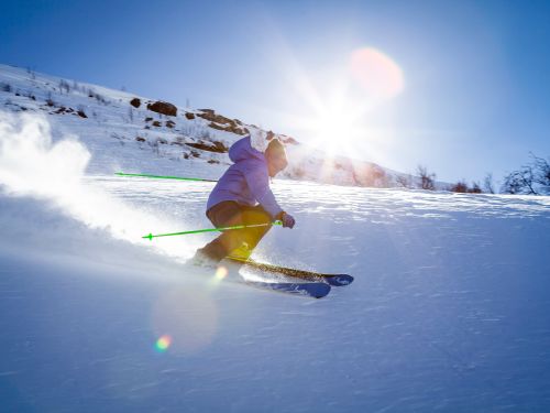 Spring Mountain in USA - a skier skiing down a slope in the sun.