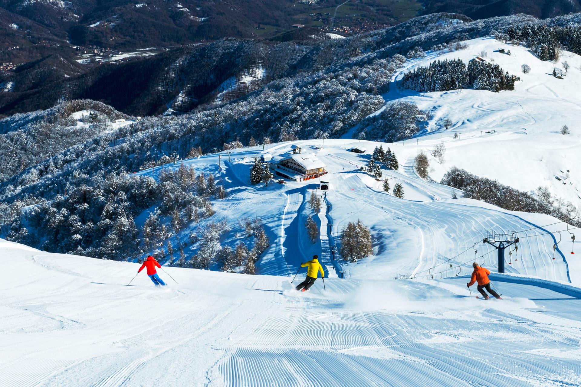 View of Lurisia Monte Pigna ski resort in Piedmont Italy showcasing a bustling winter sports scene with skiers snow and a ski lift amid stunning winter scenery.