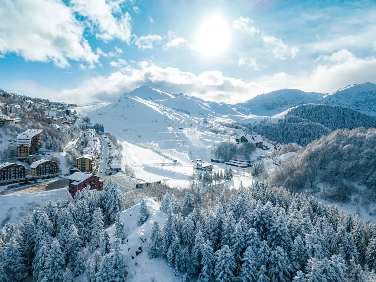 Lurisia Monte Pigna in Italy - a snowy village surrounded by trees and snow covered mountains.