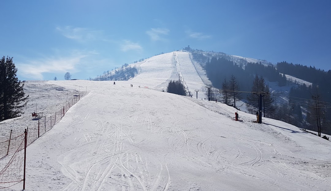 A scenic winter view at the Lurisia Monte Pigna ski resort in Italy featuring a charming chalet a skier navigating snow-covered slopes and bustling winter sports activities.