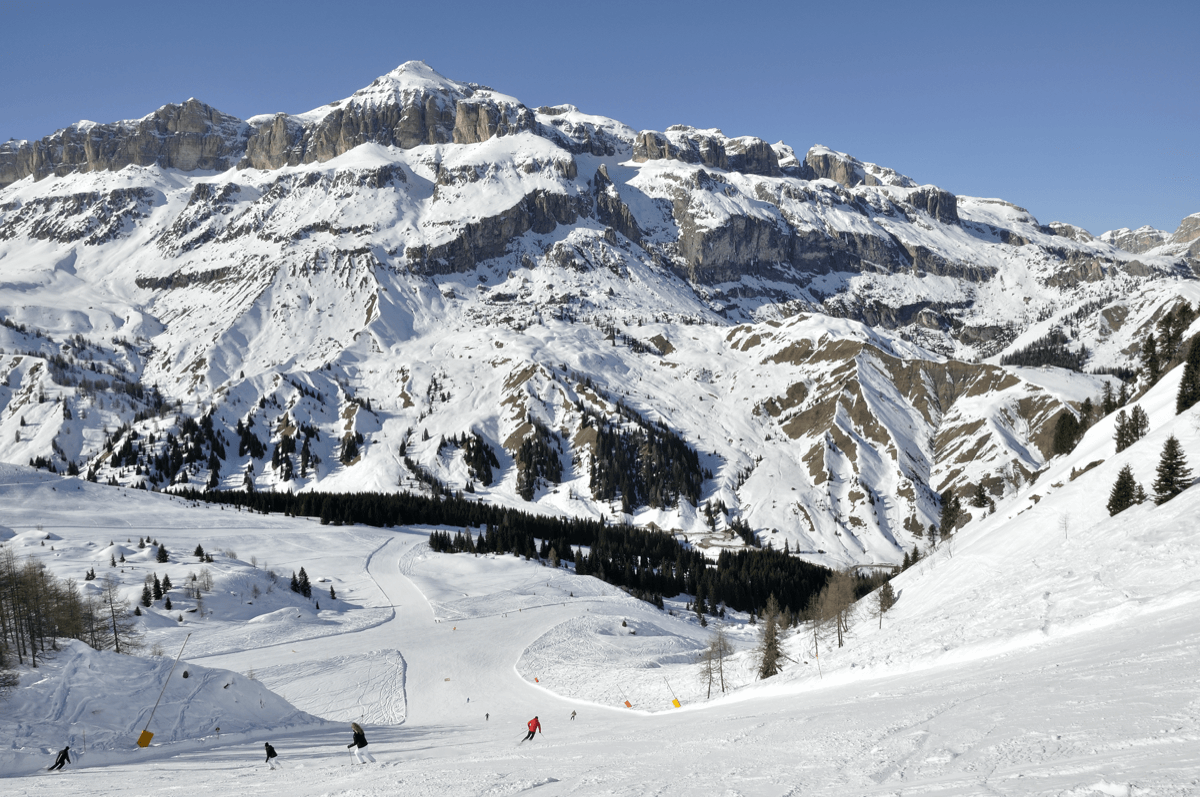 Arabba Marmolada in Italy - a group of people skiing down a mountain.
