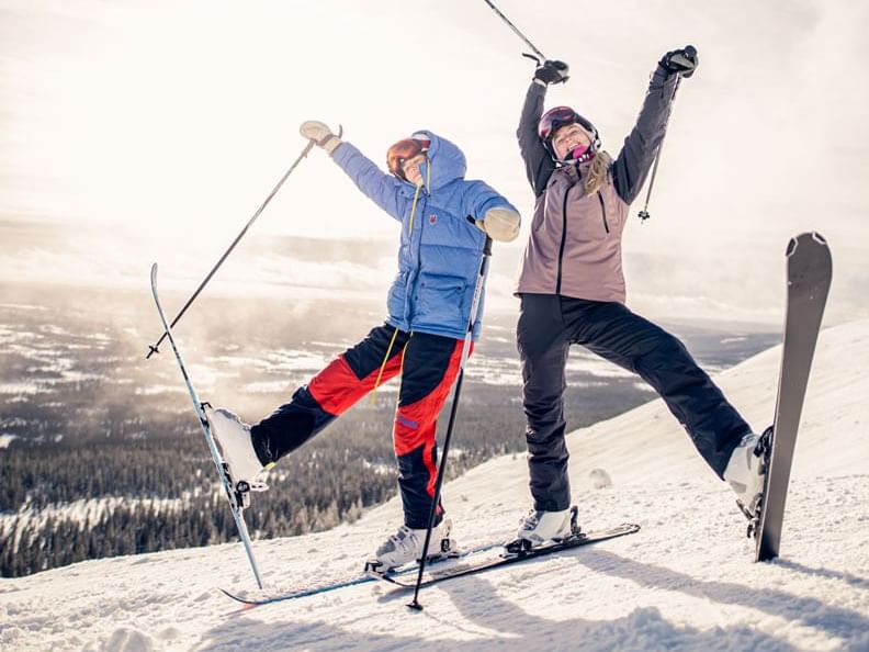 Winter sports scene at Fairmont Hot Springs in Kootenay Rockies, British Columbia, Canada, featuring a skier and a family enjoying skiing. A ski lift can be seen in the background, surrounded by the ski resort.