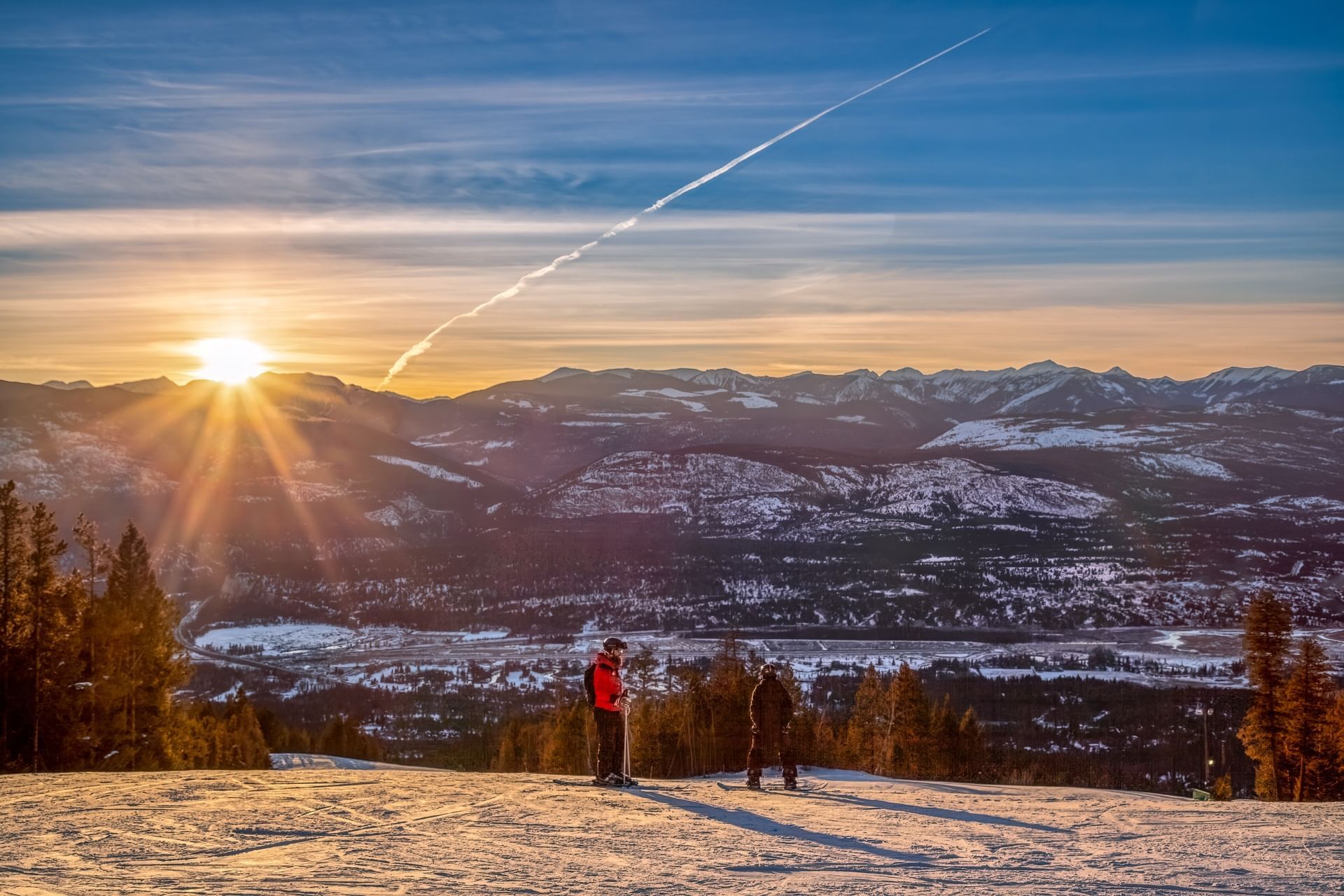 A skier enjoying a ride down the slopes at Fairmont Hot Springs ski resort in British Columbia, Canada, amidst breathtaking winter scenery, with a ski lift in view.