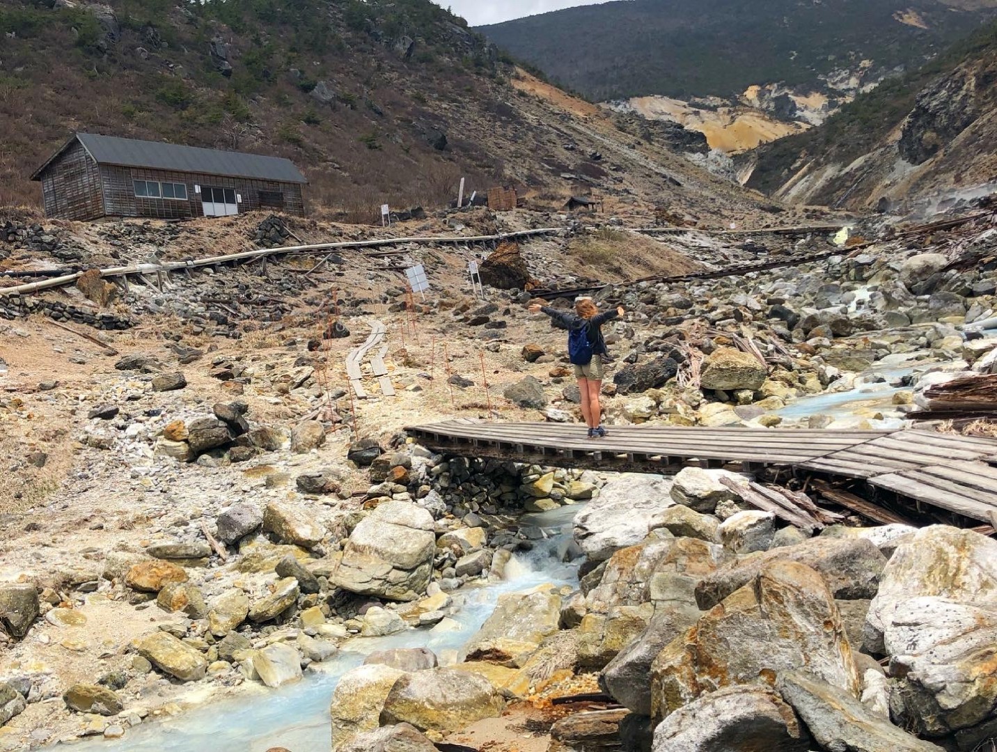 Numajiri in Japan - a man standing on a bridge over a stream.