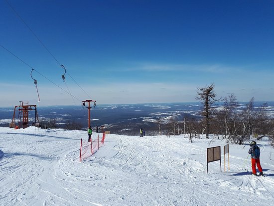 Winter sports scene at Adzhigardak in Asha Russia featuring a chalet skiers ski lift and ski resort.