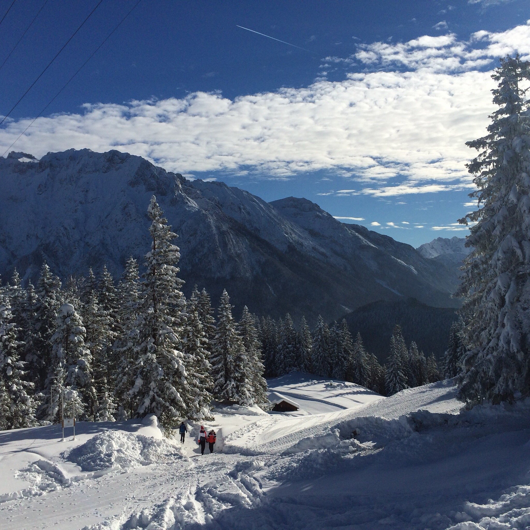 Winter sports scene in Kranzberg, with skiers enjoying the avalanches of snow in the backdrop of stunning winter scenery including a ski lift and ski resort.