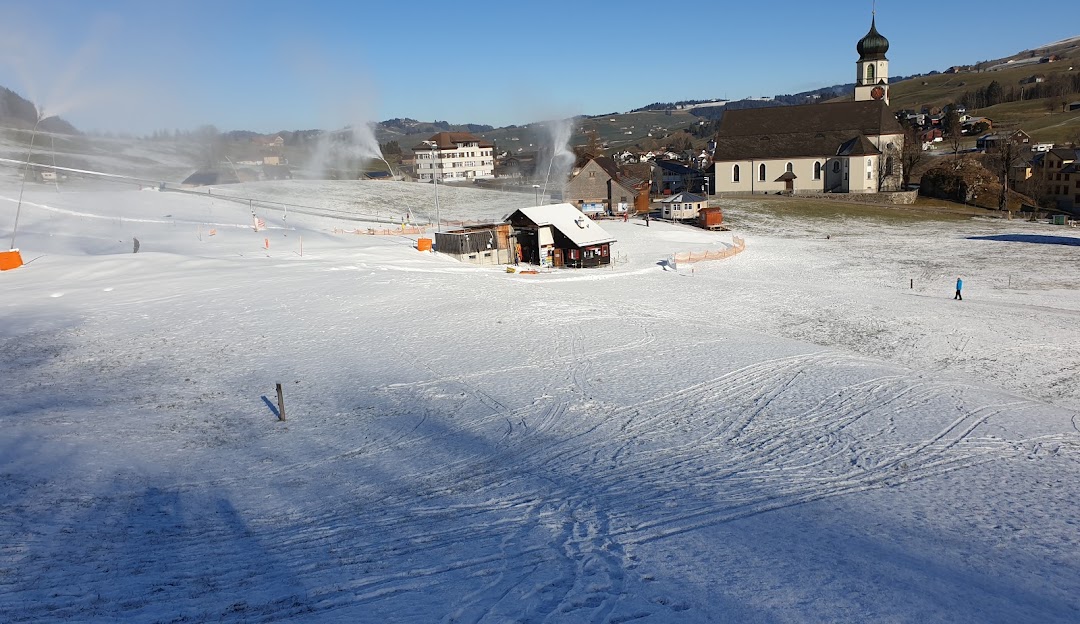 Winter sports centre set amidst the snowy peaks of Ebenalp-Horn, Appenzellerland, Eastern Switzerland. A ski resort prevalent in the scenery, with a distant chalet and ski lift visible.