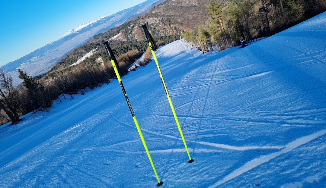A skier enjoying a winter sports scene at Lysá in Drienica Prešov Slovakia. Features a lively winter sports centre with a chalet and a visible ski lift.