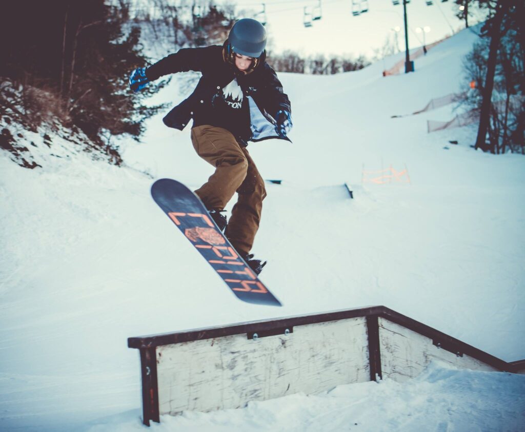 A snowboarder is skillfully skimming down the smooth, snowy slopes of Mt. La Crosse in La Crosse, Wisconsin, USA. The pristine white snow contrasts with the blue winter skies.