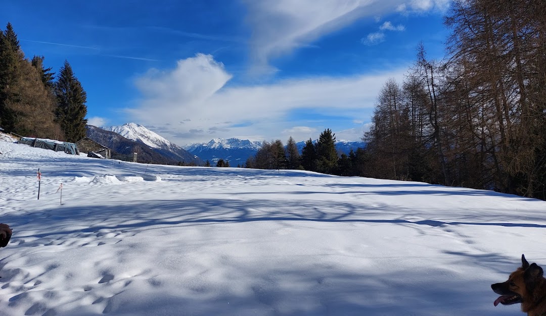 Winter scene at Alpe Teglio, Valtellina, showcasing a charming chalet amidst picturesque snow-covered mountain landscape, embodying the spirit of winter sports in Lombardy, Italy.