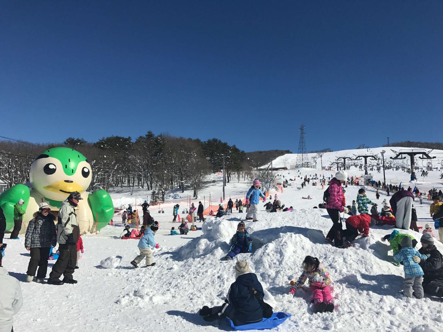 Hirugano Kogen in Japan - a group of people sitting on a snow covered hill.