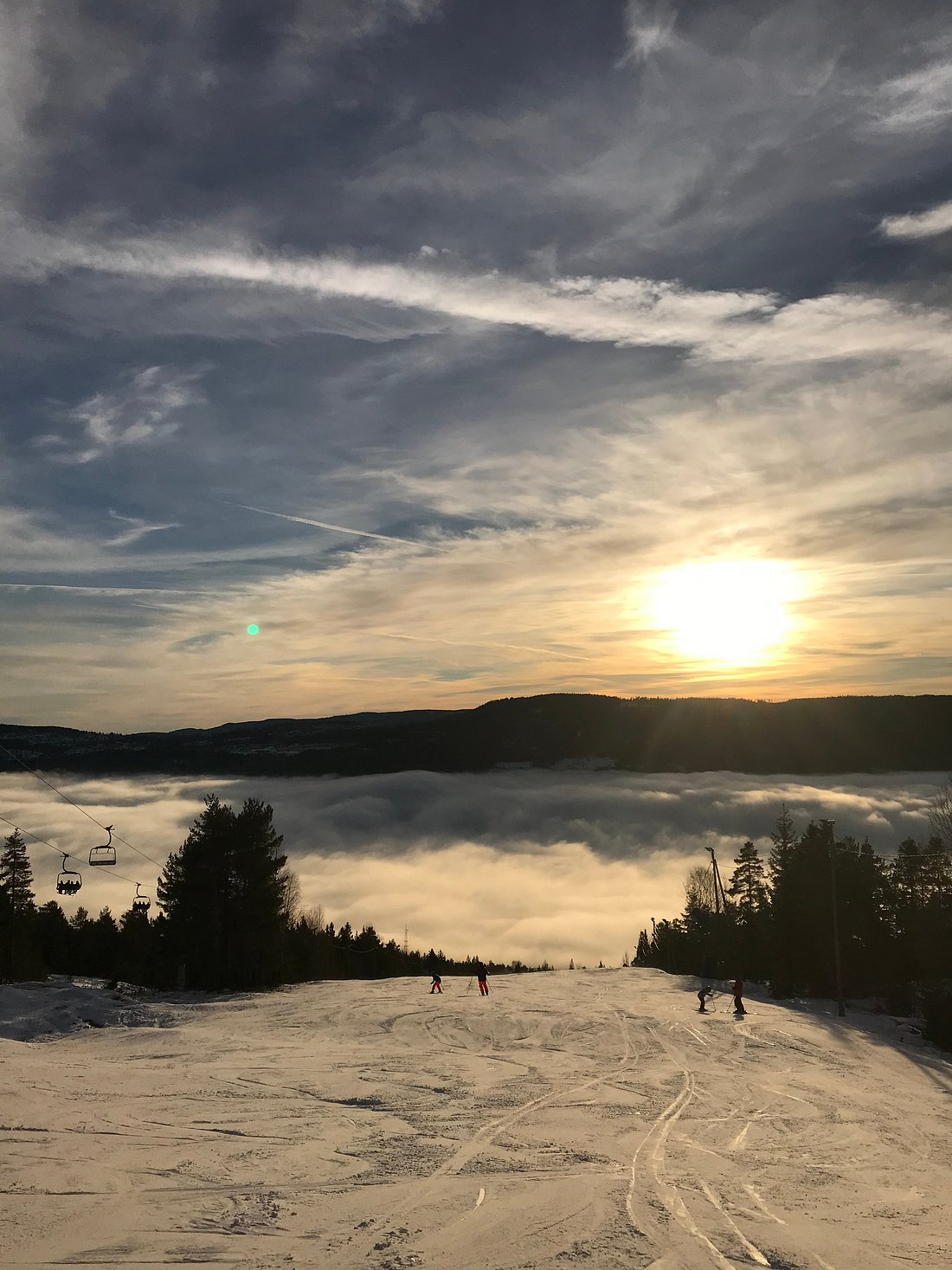 Winter sports scene at a ski resort in Drammen, Norway. A charming chalet is nestled at the base of a snowy mountain, contributing to the beautiful winter scenery.