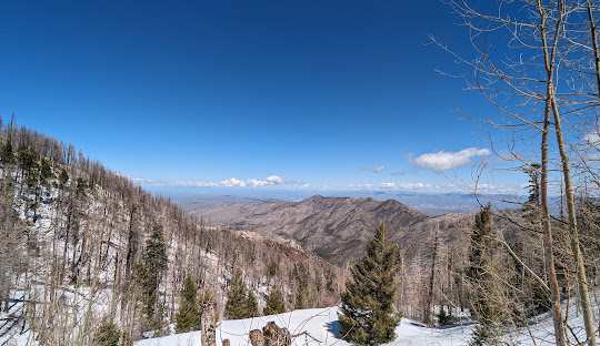 View of the snow-covered Mt Lemmon in Arizona, showcasing a bustling winter sports scene, with people participating in various activities at the ski resort.