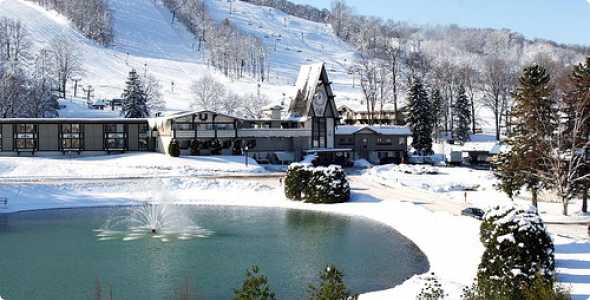 A picturesque view of Norway Mountain in Michigan, USA featuring a bustling ski resort and winter sports centre amidst stunning winter scenery, with a chalet nestled in the snow-covered landscape.