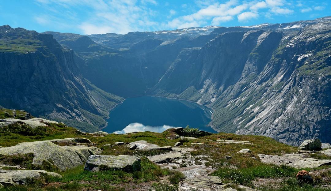 A picturesque view of Norway Mountain in Michigan showcasing a captivating lake at the mountain's base a quaint challet nearby and a subtle mountain hut with a mountain bike parked nearby.