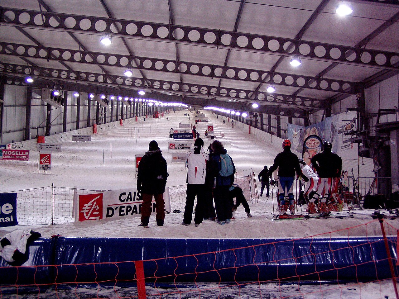 SnowWorld Amnéville in France - a group of people skiing down a snowy slope.