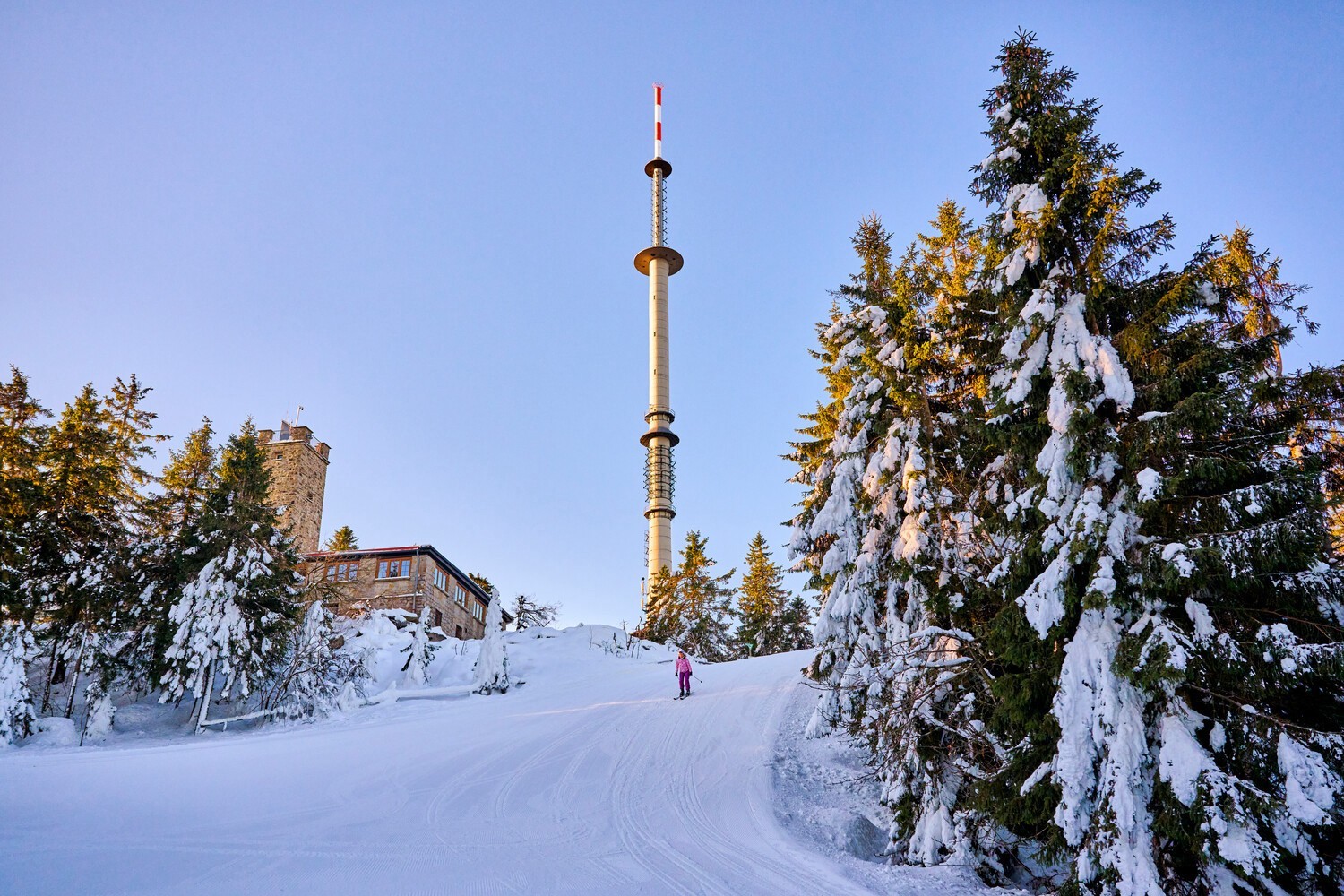 Hempelsberg | Geiersberg – Oberwarmensteinach in Germany - a person skiing down a hill with a tower in the background.