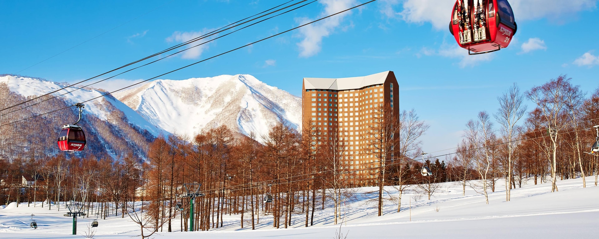 Rusutsu in Japan - a ski lift going up a snowy mountain.