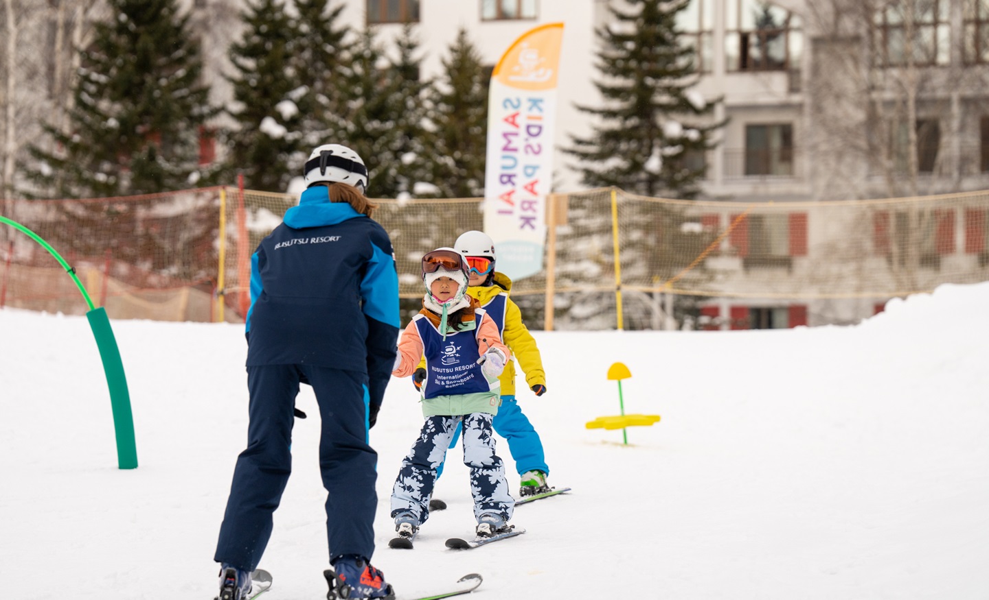 Rusutsu in Japan - a man helping a little boy to ski.