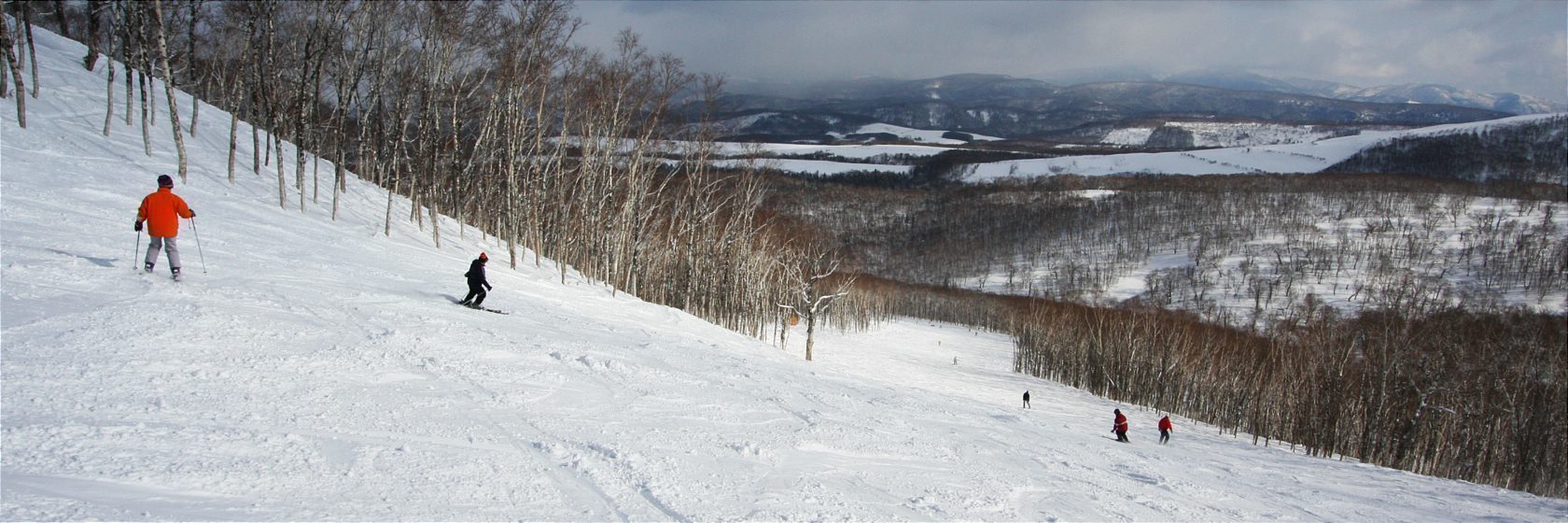 Rusutsu in Japan - a group of people skiing down a snowy slope.