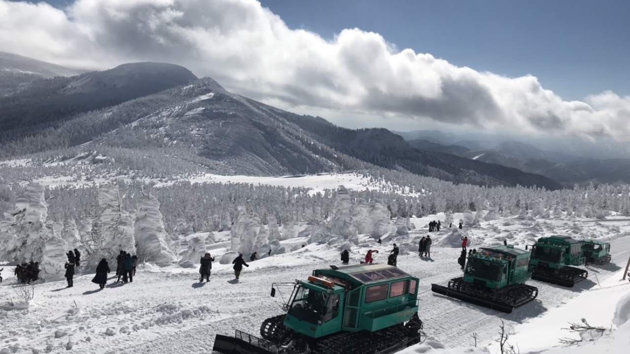 Zao Sumikawa in Japan - a group of people standing on top of a snow covered mountain.