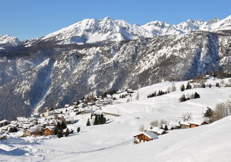 View of a ski resort in Chamois, Matterhorn, filled with chalets and winter sports enthusiasts, beautifully covered in snow, showcasing an enchanting winter scenery in Aosta, Italy.