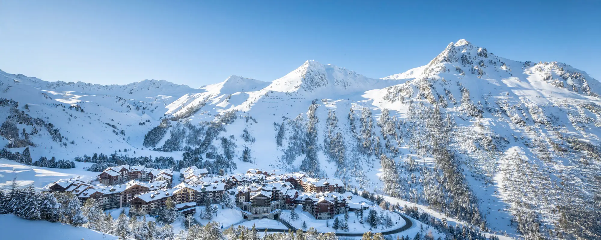 Les Arcs | Peisey-Vallandry in France: a mountain resort surrounded by snow covered trees.