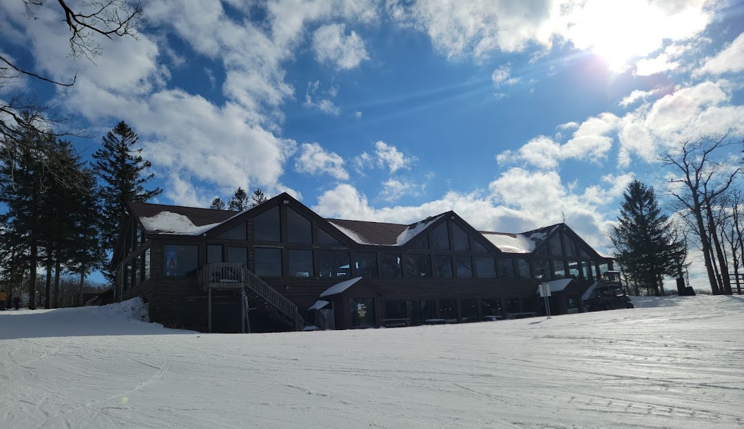 View of Laurel Mountain Ski Resort in Boswell, Pennsylvania, showcasing the main lodge, sports center and a chalet amidst a winter sports scene.